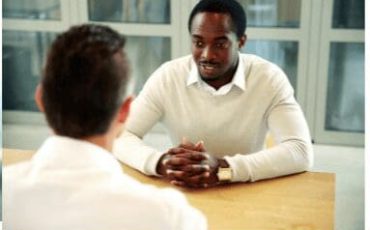 Two men talking across a table